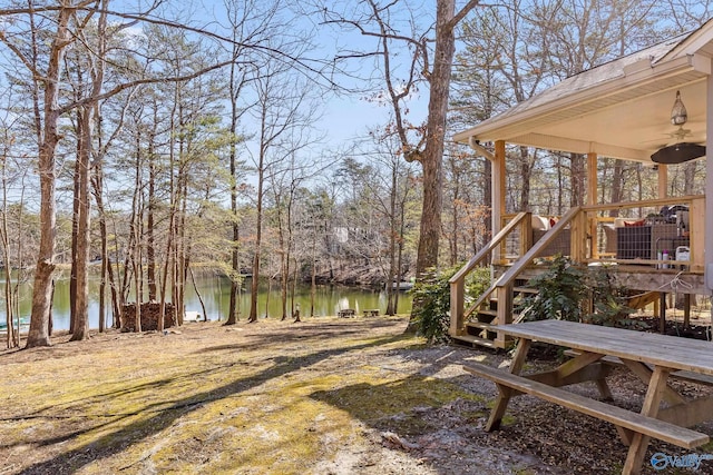 view of yard featuring a water view and a ceiling fan