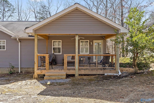 exterior space with covered porch, ceiling fan, and roof with shingles