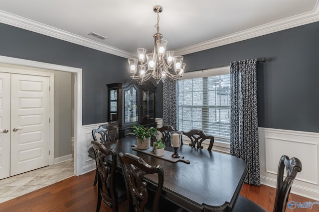 dining space featuring a notable chandelier, wood-type flooring, and crown molding