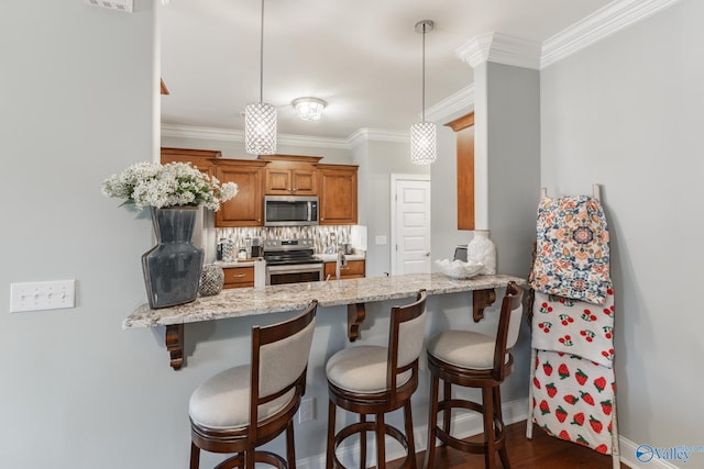 kitchen featuring decorative backsplash, appliances with stainless steel finishes, kitchen peninsula, light stone counters, and hanging light fixtures