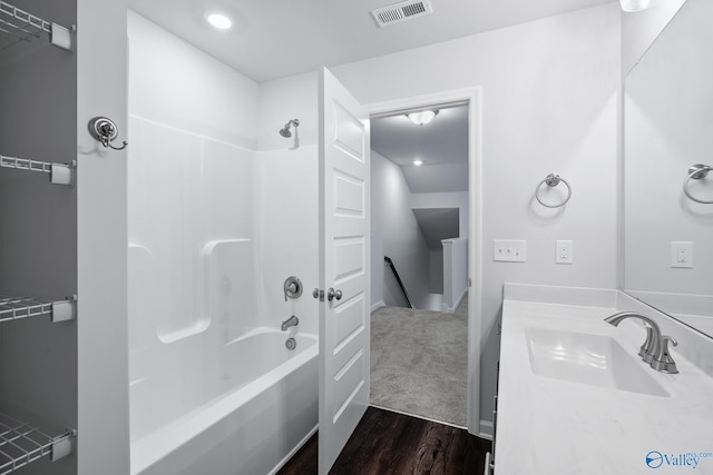 bathroom with hardwood / wood-style flooring, vanity, and  shower combination