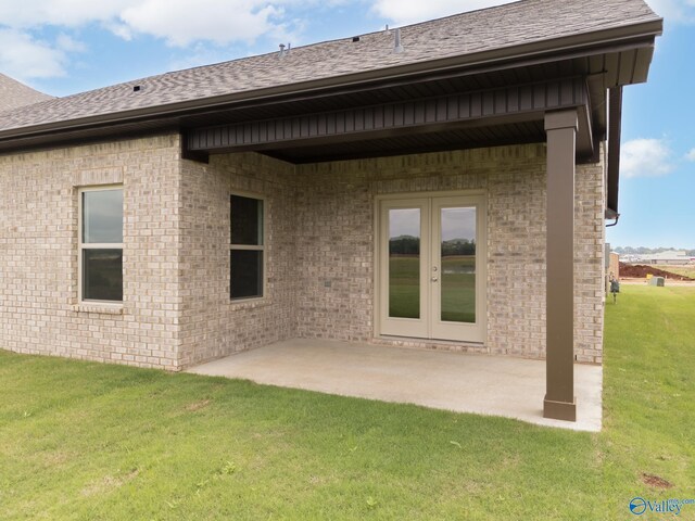 rear view of property with a patio, a lawn, and french doors