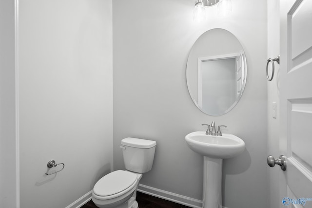 bathroom with wood-type flooring and toilet