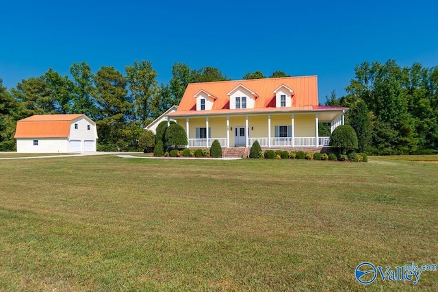 view of front of home with a garage, an outbuilding, a front lawn, and a porch