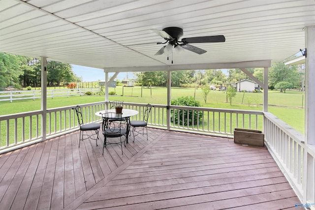 wooden deck with a lawn and ceiling fan