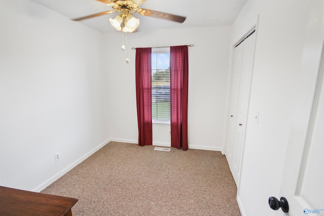 unfurnished bedroom featuring light colored carpet, ceiling fan, and a closet