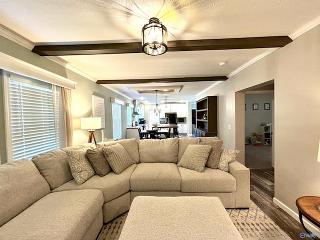 living room with beam ceiling, crown molding, baseboards, and wood finished floors