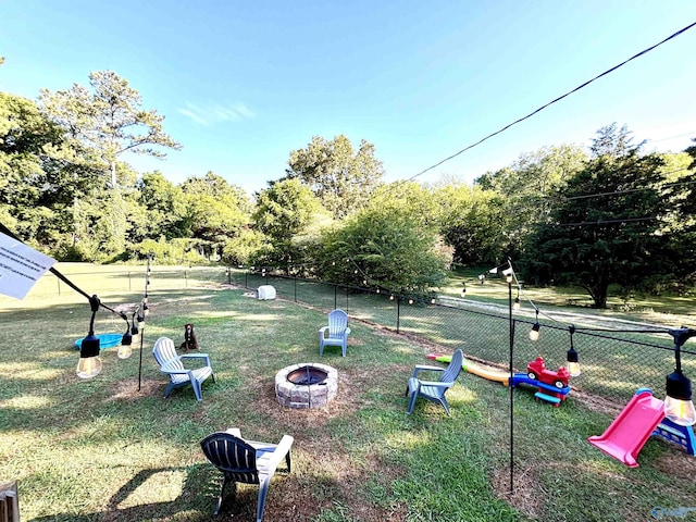 surrounding community featuring a yard, fence, and a fire pit