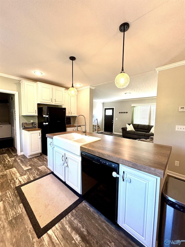 kitchen featuring ornamental molding, dark countertops, a sink, and black appliances