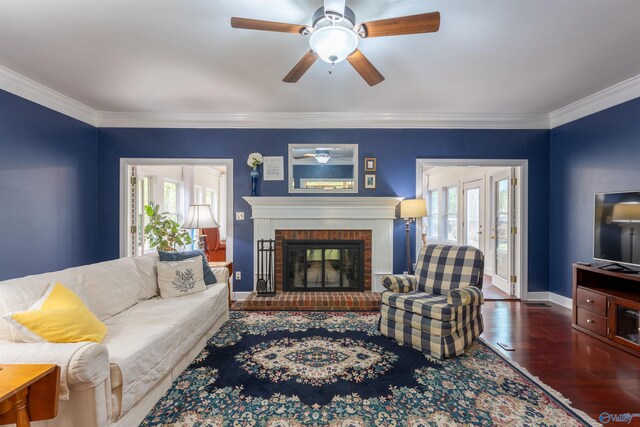 living room with a brick fireplace, a wealth of natural light, ceiling fan, and dark hardwood / wood-style floors