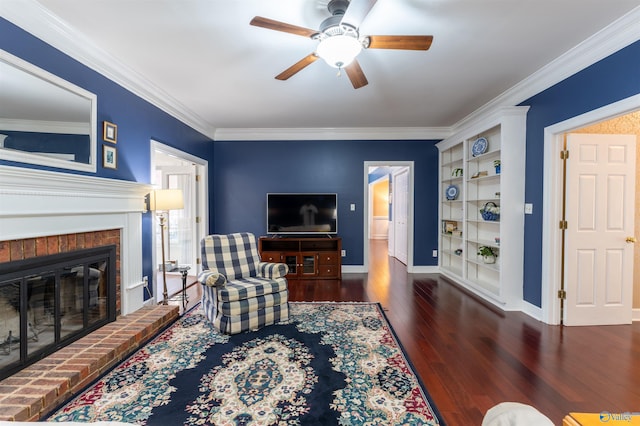 living room featuring a brick fireplace, dark hardwood / wood-style flooring, ceiling fan, built in features, and ornamental molding