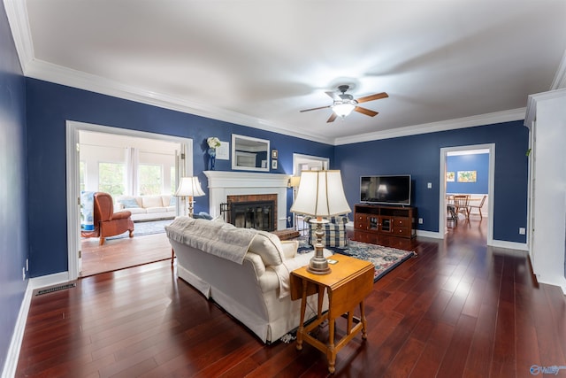 living room featuring ornamental molding, ceiling fan, dark hardwood / wood-style floors, and a fireplace