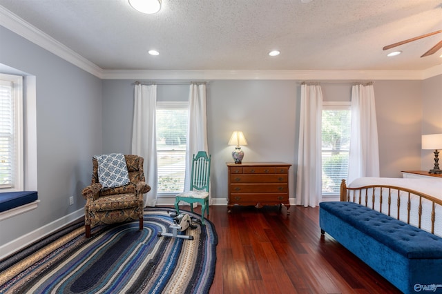 sitting room featuring a textured ceiling, ornamental molding, dark hardwood / wood-style flooring, and ceiling fan