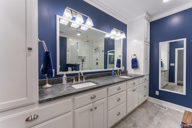 bathroom featuring ornamental molding, tile patterned flooring, a shower with door, and vanity