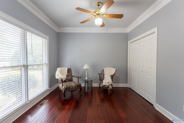 sitting room featuring ceiling fan, crown molding, and dark wood-type flooring