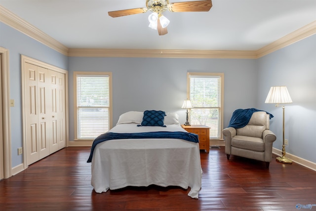 bedroom with ornamental molding, dark wood-type flooring, ceiling fan, and a closet