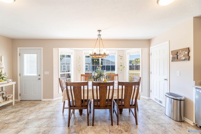 dining space with a healthy amount of sunlight and a notable chandelier