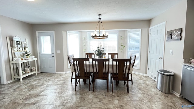 dining space with an inviting chandelier and a textured ceiling