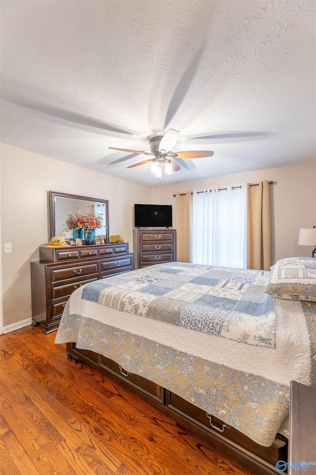 bedroom featuring ceiling fan, hardwood / wood-style floors, and a textured ceiling