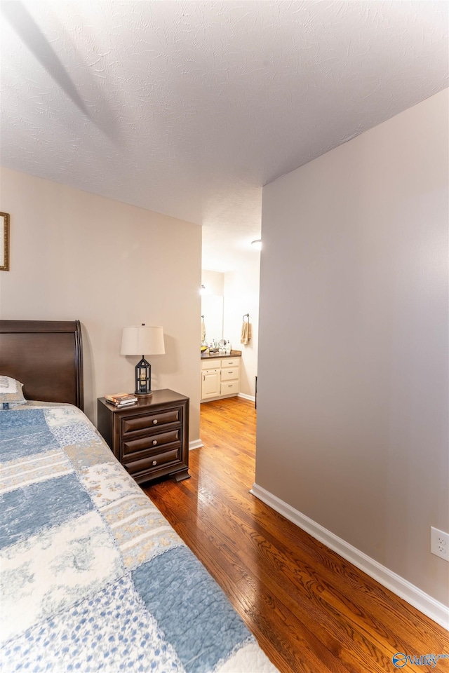 bedroom with wood-type flooring and a textured ceiling