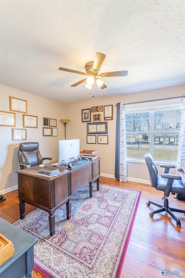 office area featuring hardwood / wood-style flooring, a textured ceiling, and ceiling fan