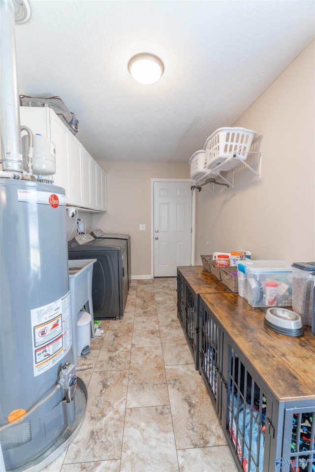 laundry room with independent washer and dryer, cabinets, and water heater