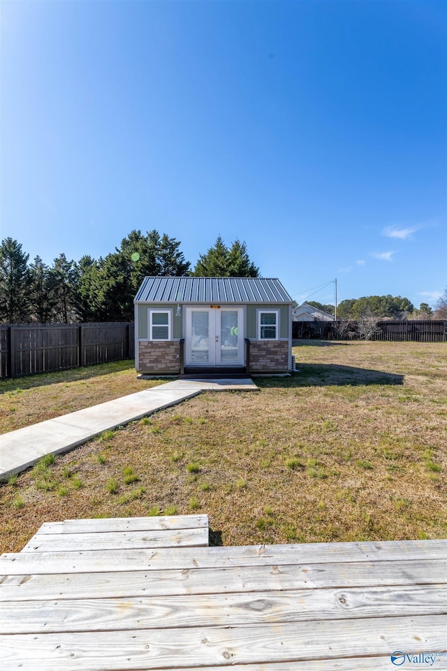 view of front of property with french doors, an outbuilding, and a front yard