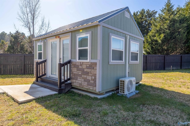 view of outdoor structure with a yard and ac unit