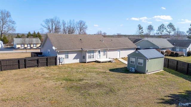 rear view of property with a yard and a storage unit