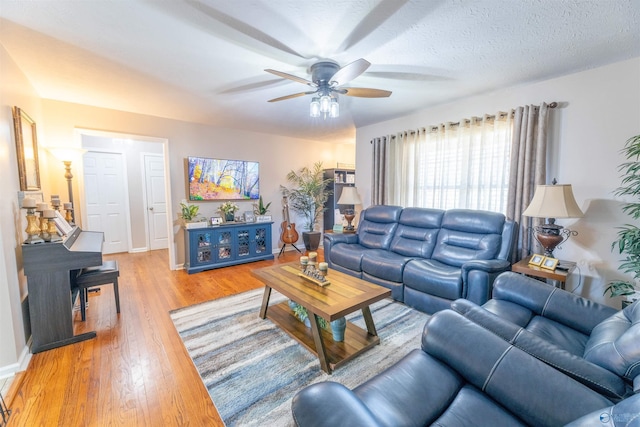 living room with ceiling fan, wood-type flooring, and a textured ceiling