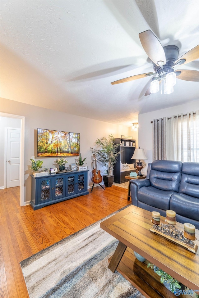 living room with wood-type flooring and ceiling fan