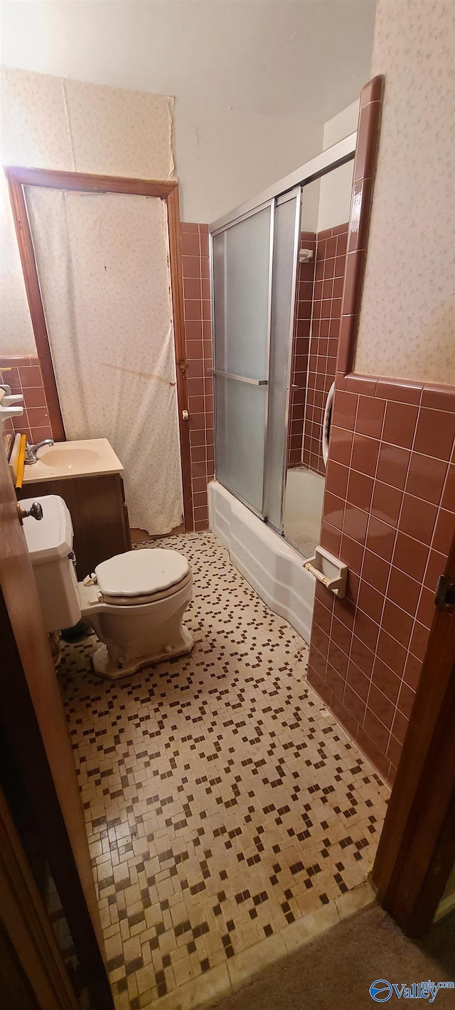 full bathroom featuring tile walls, sink, tile patterned flooring, and enclosed tub / shower combo