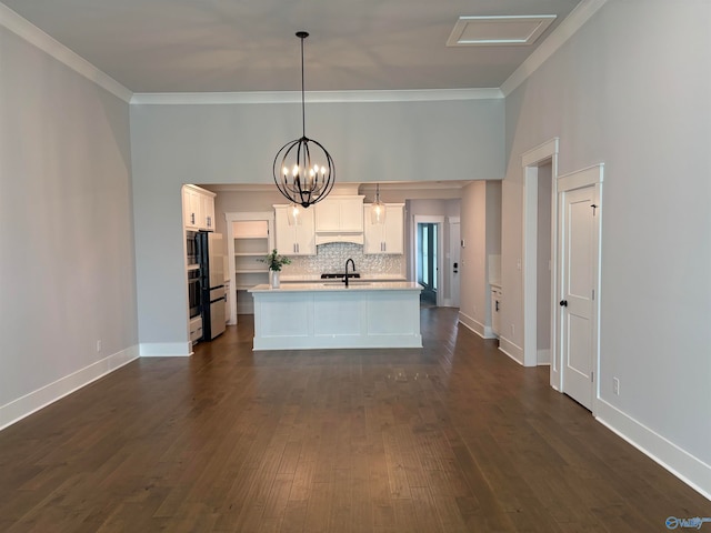 kitchen featuring pendant lighting, white cabinets, an island with sink, sink, and dark wood-type flooring