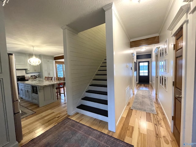 620 County Road 40, Centre, AL 35960 - stairs with a notable chandelier, crown molding, a textured ceiling, and wood finished floors