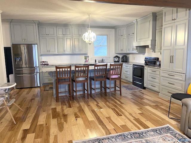 620 County Road 40, Centre, AL 35960 - kitchen featuring light wood-style flooring, stainless steel fridge, electric range, and a kitchen breakfast bar