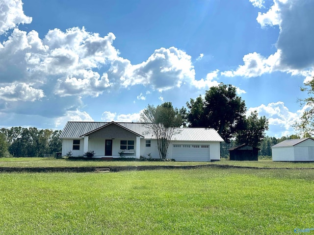 single story home featuring a front yard, a garage, and a storage shed