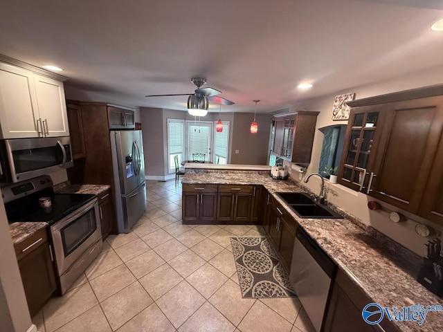 2451 Cedar Ridge Cir, Hokes Bluff, AL 35903 - kitchen featuring stainless steel appliances, light tile patterned floors, a peninsula, glass insert cabinets, and dark brown cabinetry