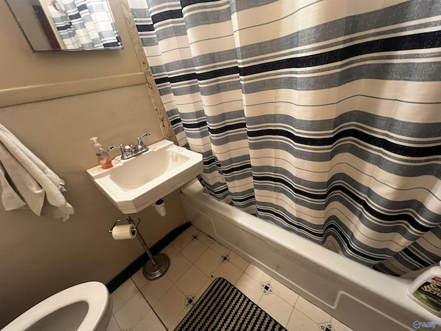 full bathroom featuring a sink, shower / bath combo with shower curtain, toilet, and tile patterned flooring