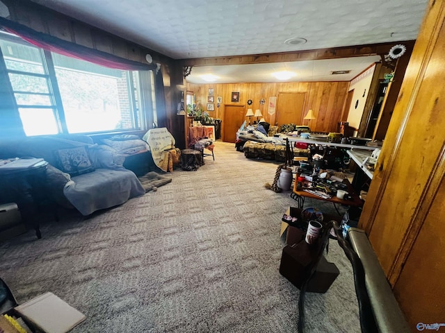 carpeted living area with wooden walls
