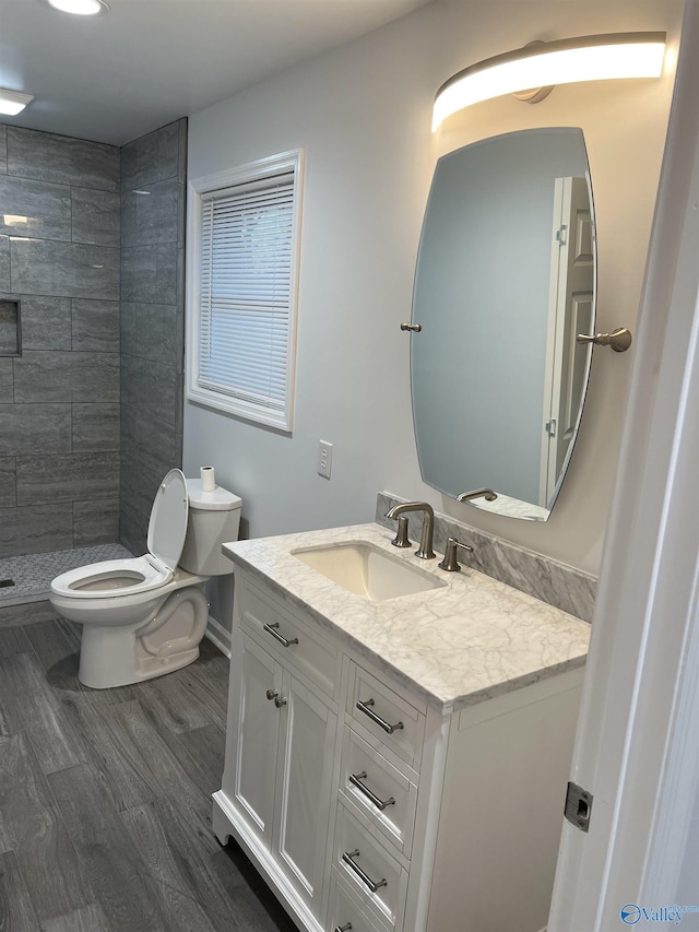 212 Nelson St NW, Hartselle, AL 35640 - bathroom with toilet, tiled shower, hardwood / wood-style floors, and vanity