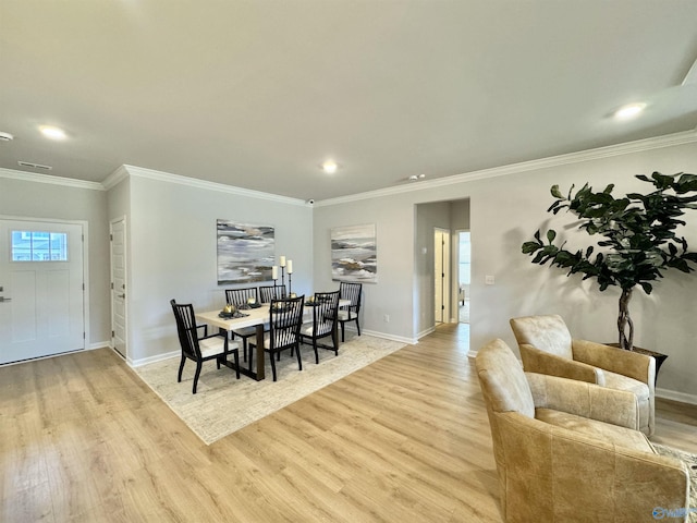 dining space with light hardwood / wood-style floors and ornamental molding