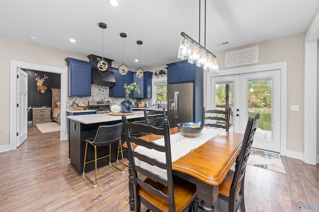 dining space featuring french doors and light wood-type flooring