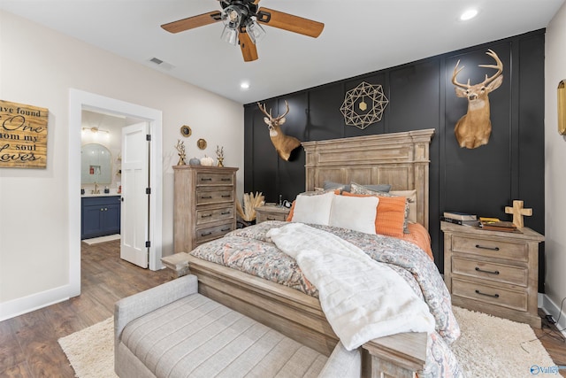 bedroom featuring ceiling fan, dark hardwood / wood-style flooring, sink, and ensuite bath