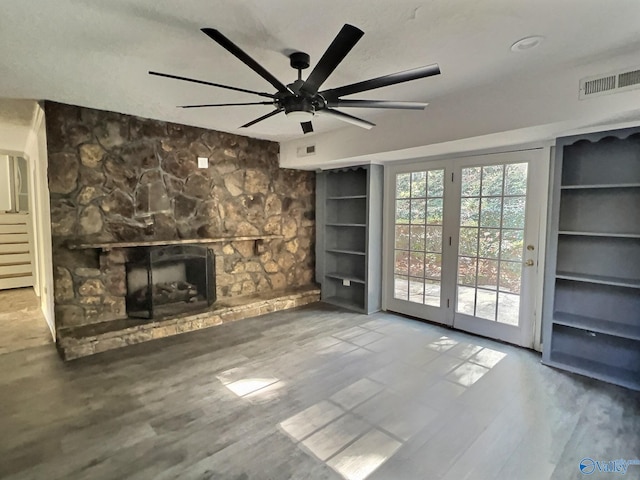 unfurnished living room featuring ceiling fan, a fireplace, built in features, and hardwood / wood-style flooring