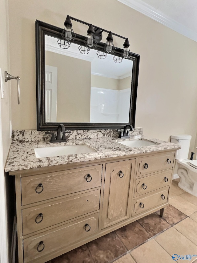 bathroom with tile patterned floors, vanity, toilet, and ornamental molding