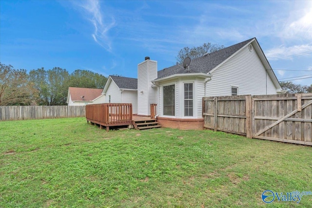 rear view of house with a lawn and a deck