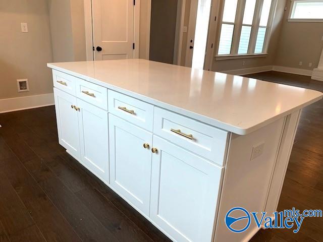 kitchen featuring white cabinetry, dark hardwood / wood-style floors, a wealth of natural light, and a kitchen island