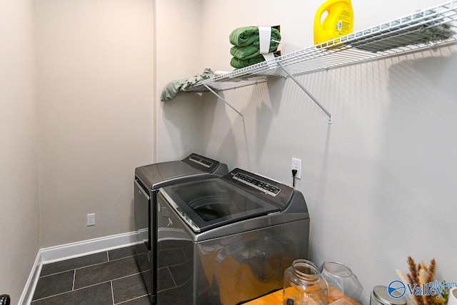 laundry room featuring separate washer and dryer and dark tile patterned flooring