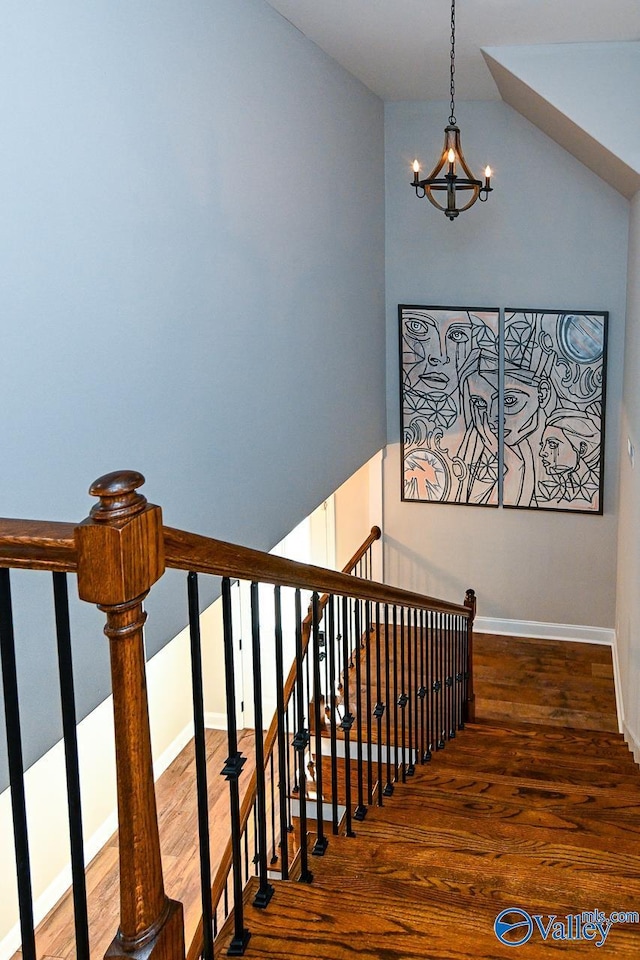 stairs featuring hardwood / wood-style flooring and a chandelier