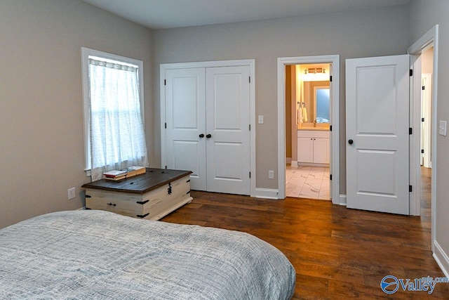 bedroom featuring connected bathroom, dark hardwood / wood-style floors, and a closet